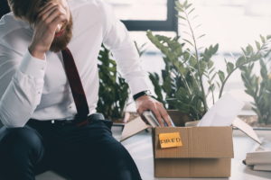 Business man recently fired sitting on a desk