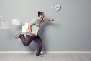 Man holding papers and looking at watch running late for a meeting