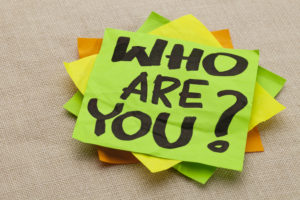 Green yellow and orange sticky notes note with words "Who are you?"